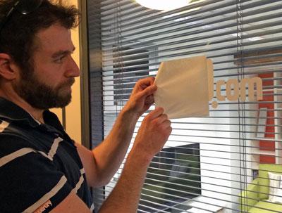 Peeling back a tr10 logo sticker on the office window